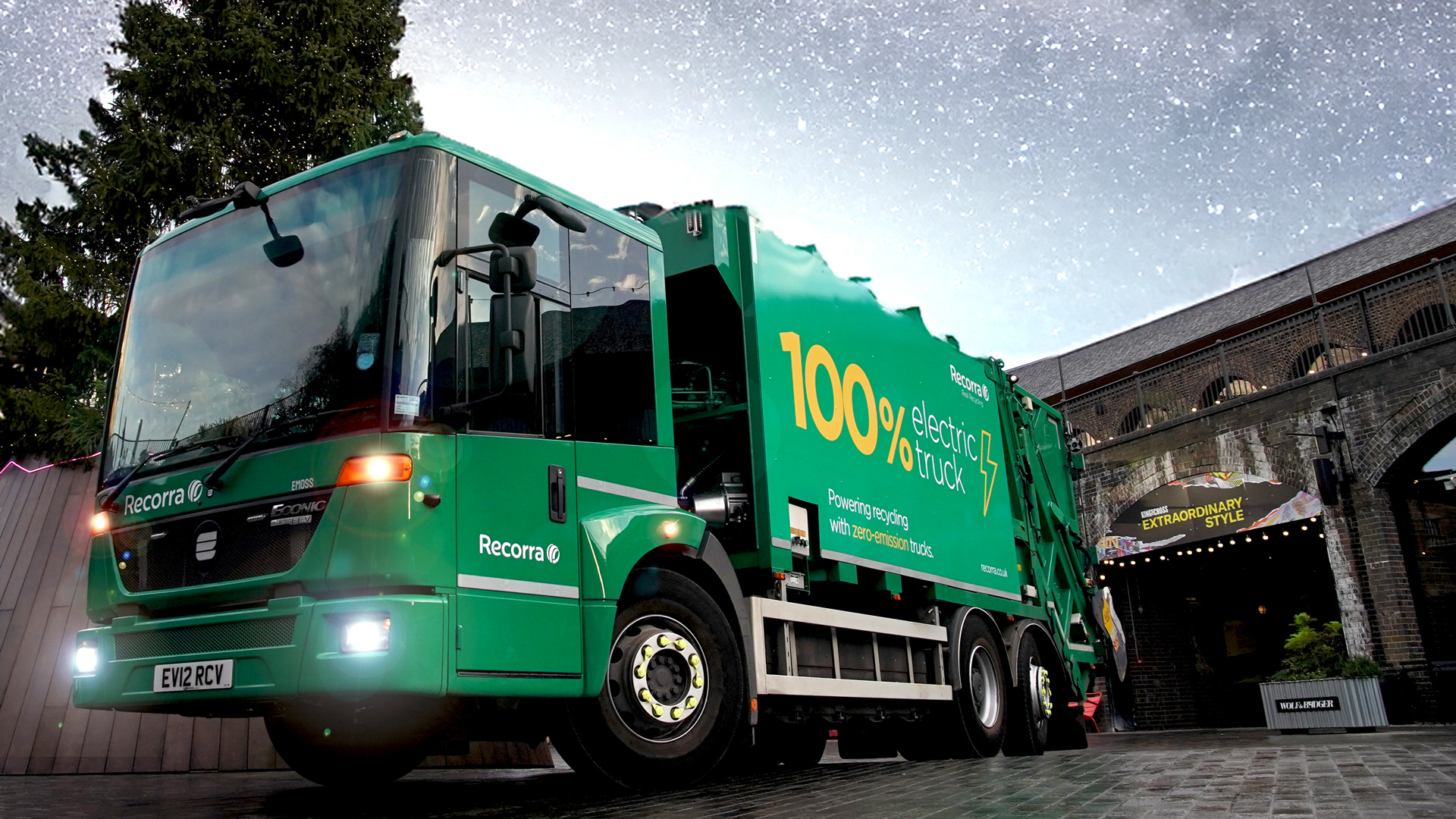 A green Recorra electric collection truck photographed outdoors